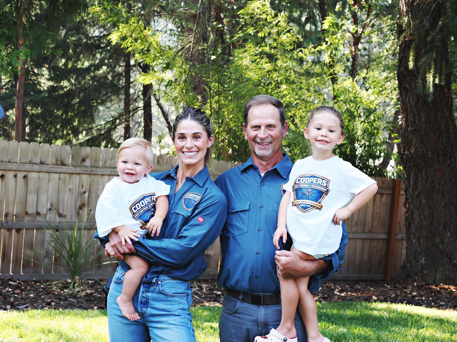 Three generations of the Cooper's Pest Control family standing together outdoors