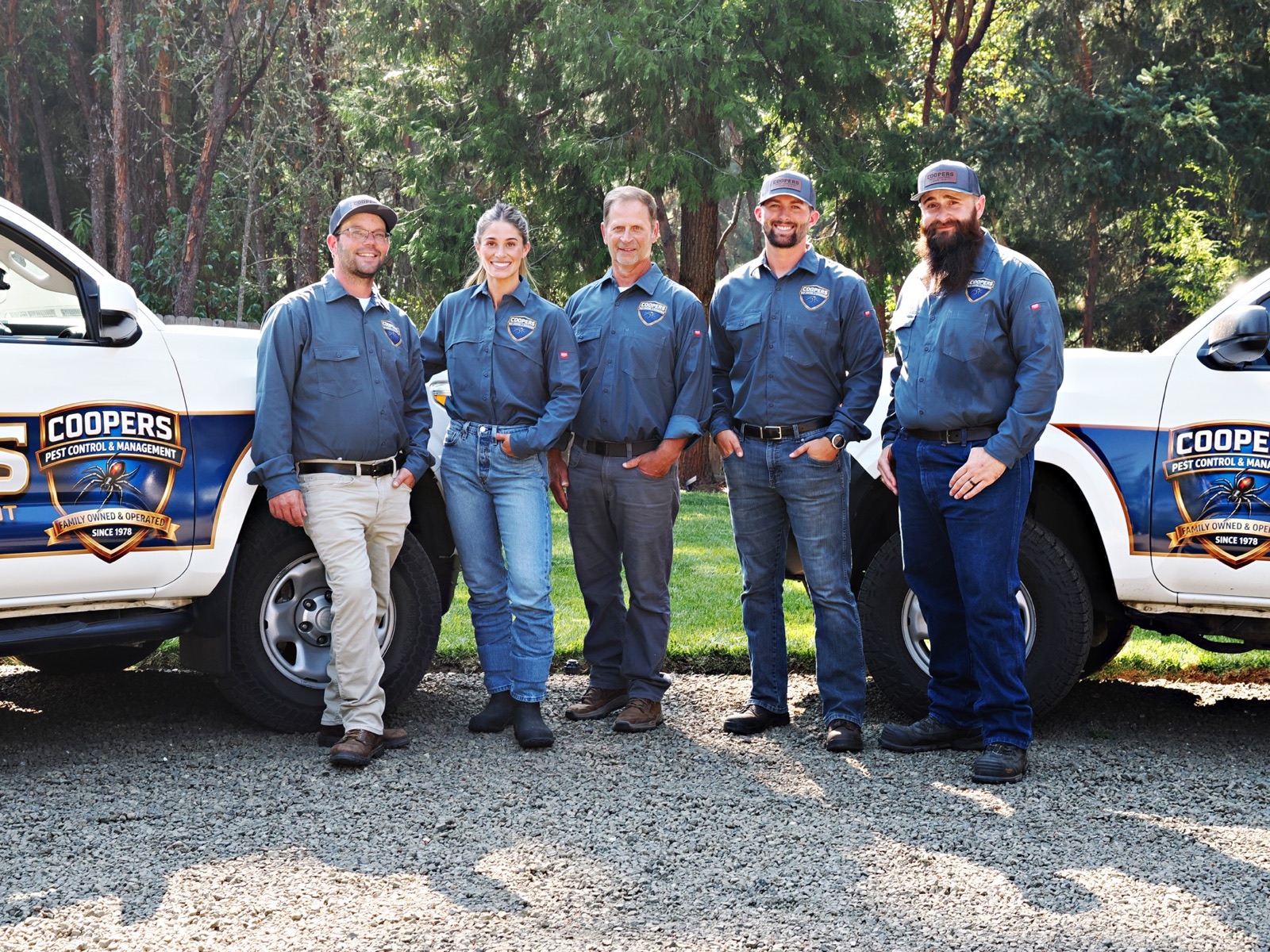 Cooper's Pest Control team standing between branded service trucks